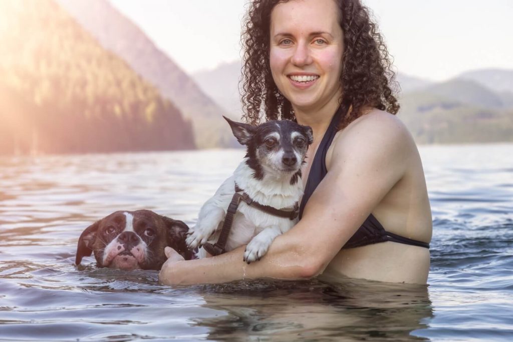Maîtresse protégeant ses deux chiens dans un lac